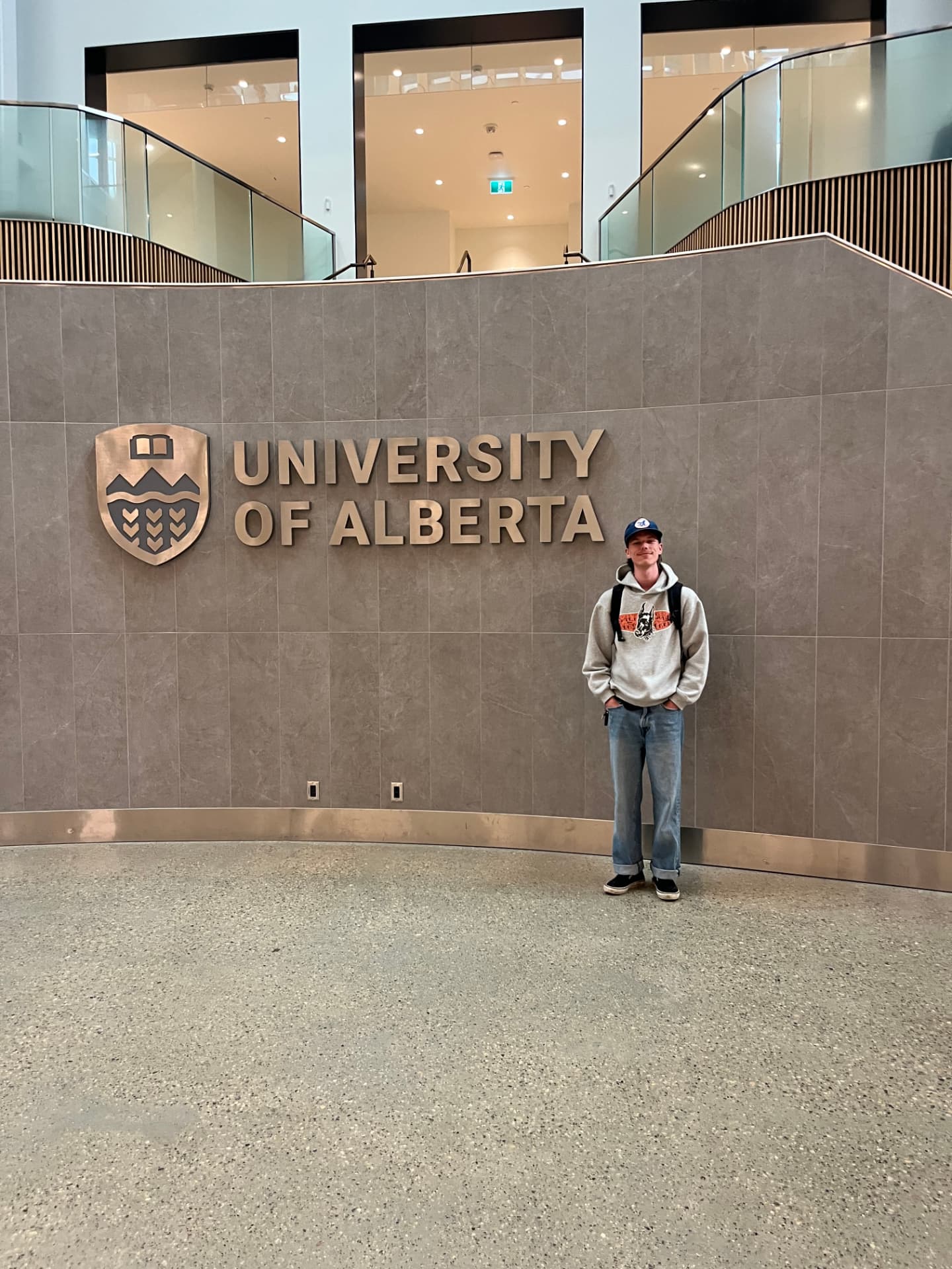 Owen standing in front of the University of Alberta sign