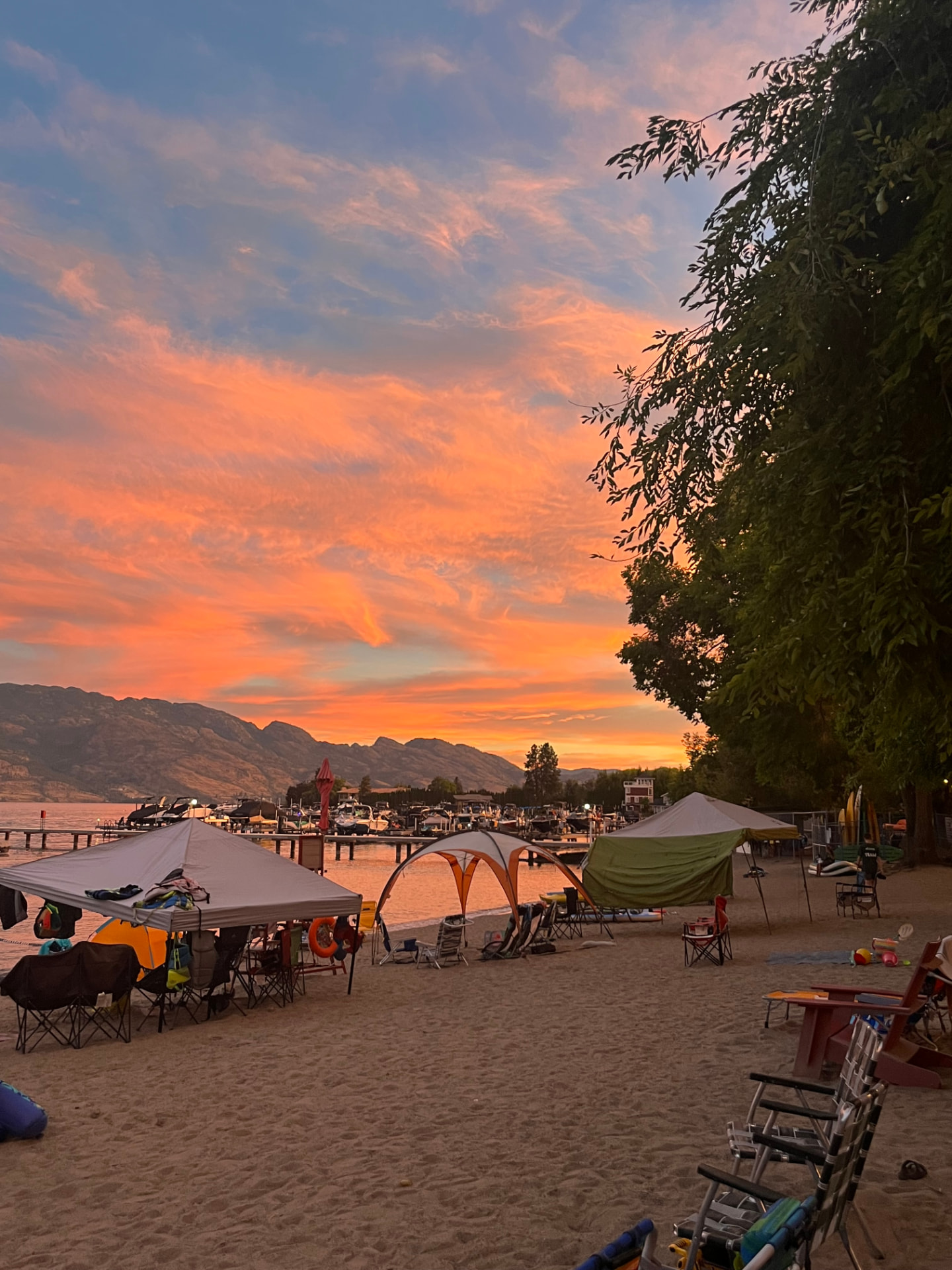 Beach camp setup under a colourful sunset sky
