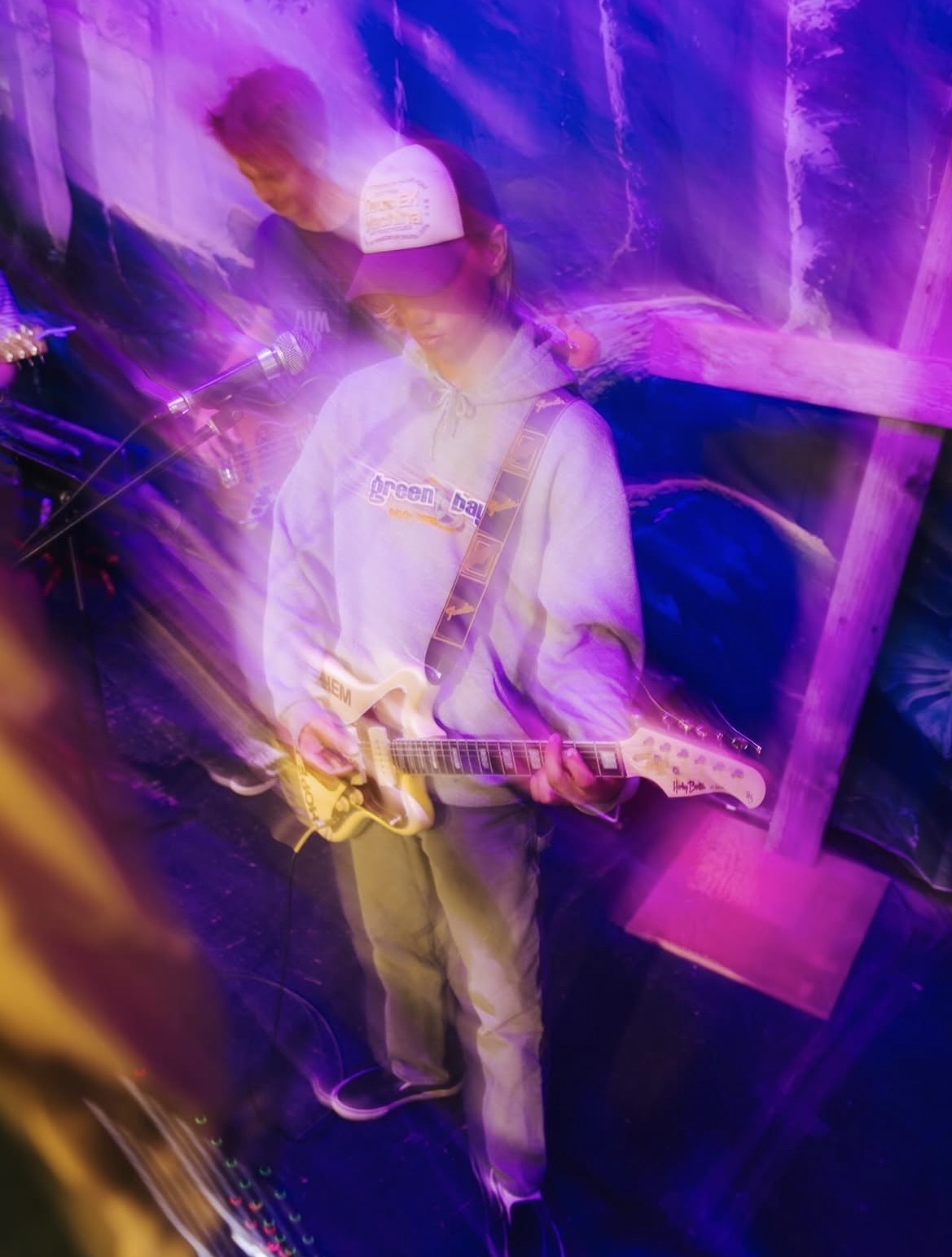 Long-exposure shot of Owen playing guitar at a camp show